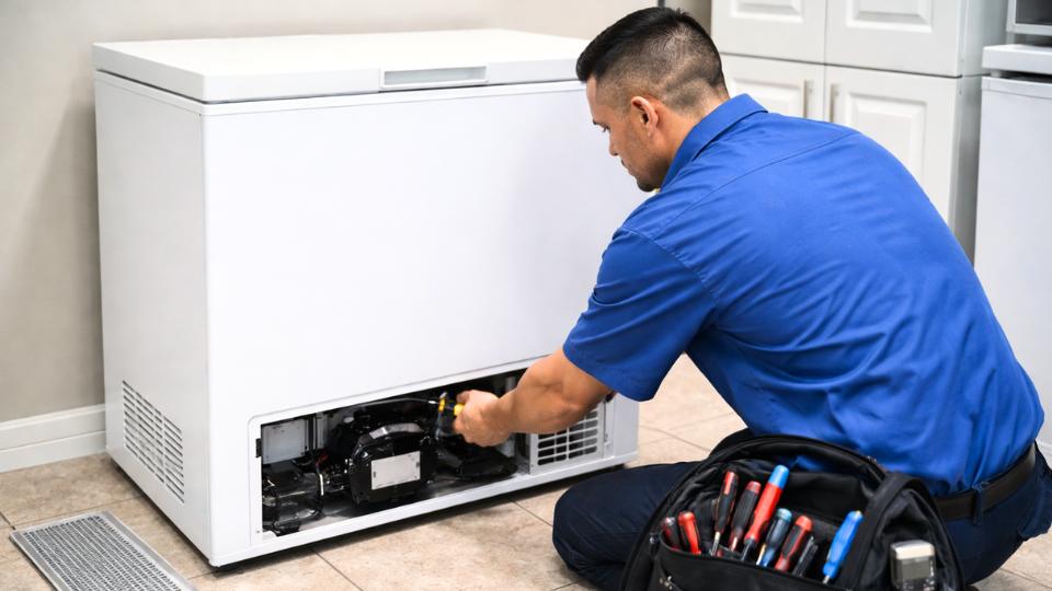 Appliance repair technician with a tool bag in a Naperville, IL home