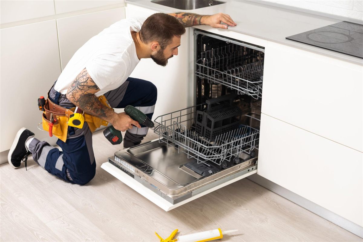 Technician performing dishwasher repair work in a Naperville kitchen