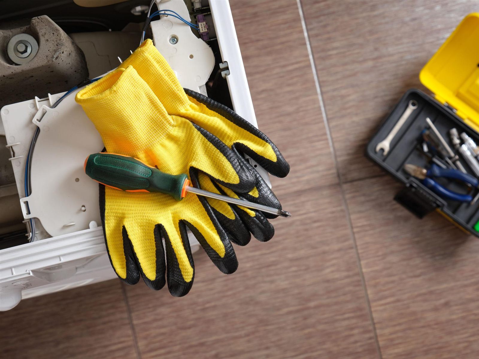 Appliance repair technician working on a kitchen appliance in a Naperville, IL home