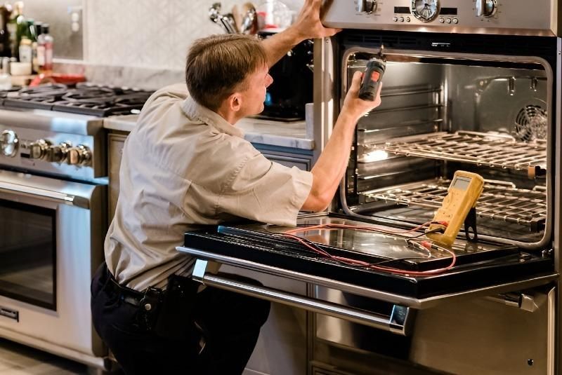 Technician performing stove and oven repair work in a Naperville kitchen