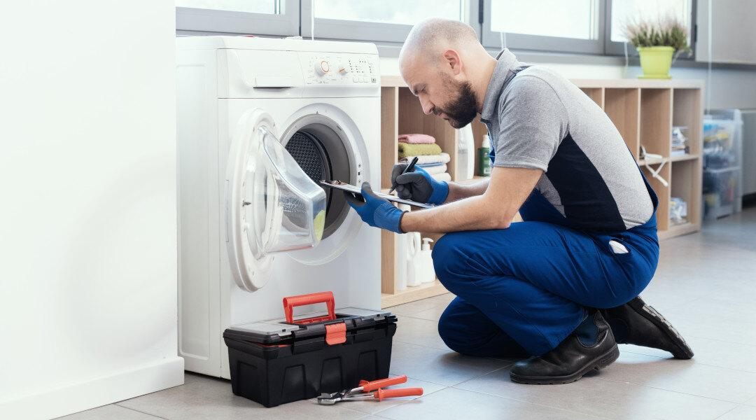 Technician diagnosing a washing machine's drum and drive components